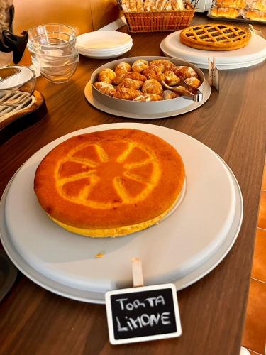 a table with a pie on a white plate with a sign at Aniene Home Roma in Rome