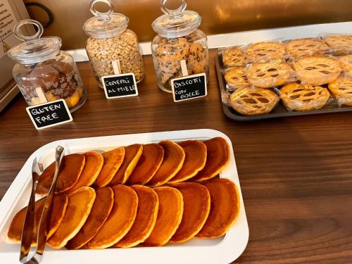 a table with a tray of bread and jars of food at Aniene Home Roma in Rome