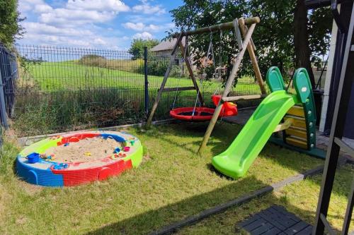 a playground with two play equipment in a yard at Stylowy Apartament z ogrodem in Gorenice