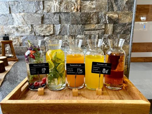 a wooden tray with four different types of bottles of juice at Hotel Natura in Zreče