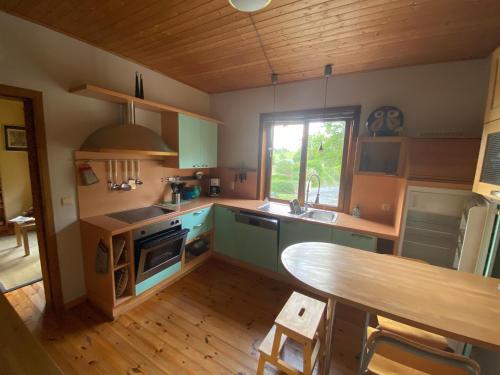 a kitchen with green cabinets and a wooden table at Vakantiehuis Bourseigne in Gedinne
