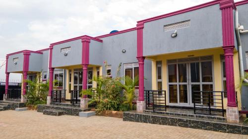 a row of houses with pink and gray at Joshean Apartments in Wakiso
