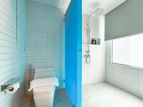 a blue bathroom with a toilet and a shower at Citrus Sukhumvit 13 Nana Bangkok by Compass Hospitality - Newly Renovated in Bangkok