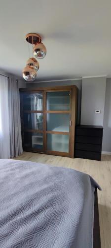 a bedroom with a bed and a large window at Stylowy Apartament z ogrodem in Gorenice
