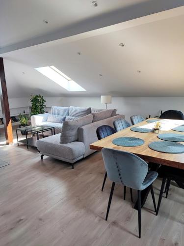 a living room with a table and a couch at Stylowy Apartament z ogrodem in Gorenice