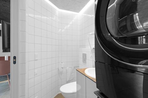 a bathroom with a toilet and a washer and dryer at Family-Friendly Holiday Homes In Fun Art, Blokhus in Pandrup