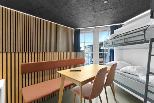 a bedroom with a table and chairs and a bunk bed at Family-Friendly Holiday Homes In Fun Art, Blokhus in Pandrup