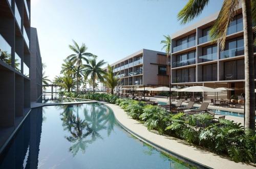 a resort swimming pool with chairs and palm trees at Paraíso Porto Alto in Porto De Galinhas