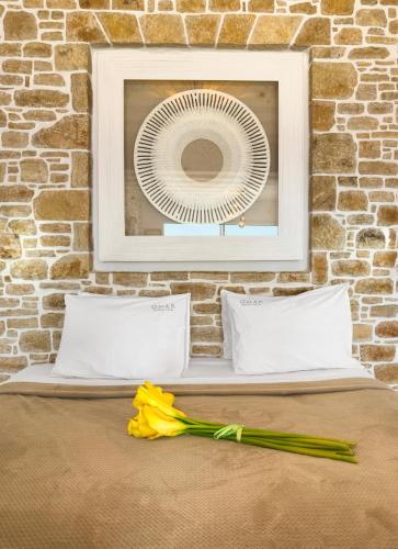 a picture of a fan and yellow flowers on a bed at Onar Suites & Villas in Karavostasi