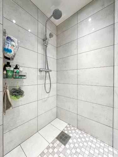 a bathroom with a shower with a glass door at Pirtelė Rykštelė in Karmėlava
