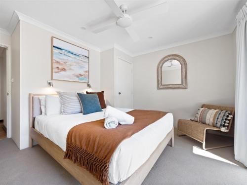 a white bedroom with a large bed and a chair at Inji Homestead - 5 acre holiday home in Margaret river region in Yallingup