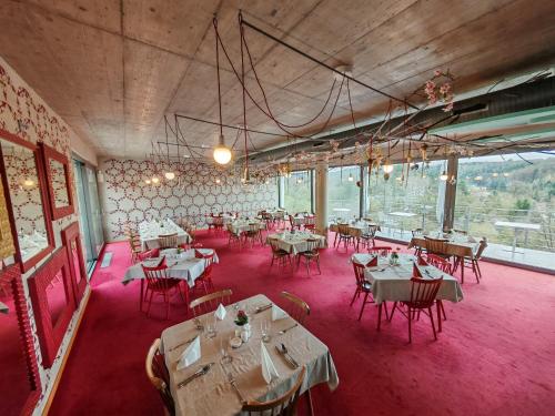a dining room with tables and chairs and a large window at Hotel Rajská zahrada in Nové Město nad Metují