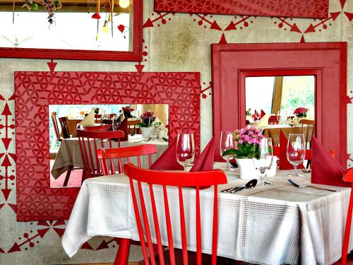 a dining room with red chairs and tables in a restaurant at Hotel Rajská zahrada in Nové Město nad Metují