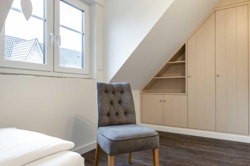 a bedroom with a chair next to a bed at Haus Jensen 3 in List