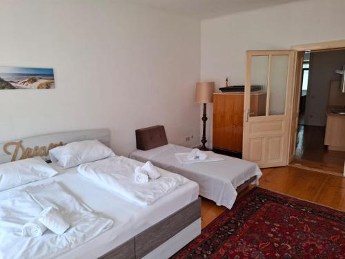 a bedroom with two beds and a chair and a door at Madar Café Restaurant zum Fürsten in Melk