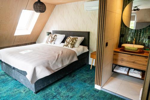 a bedroom with a large bed and a mirror at Boetiekhotel Het Huis in Fluitenberg