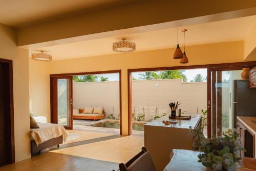 a kitchen and living room with sliding glass doors at Vila Harmonia sua casa na Praia do Preá in Prea