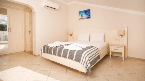 a bedroom with a bed with a striped blanket at Blue Star Hotel in Oludeniz