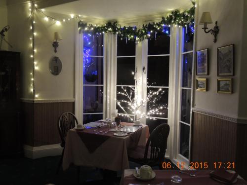 a dining room with a table and a window with lights at Orchard House Hotel in Lynmouth