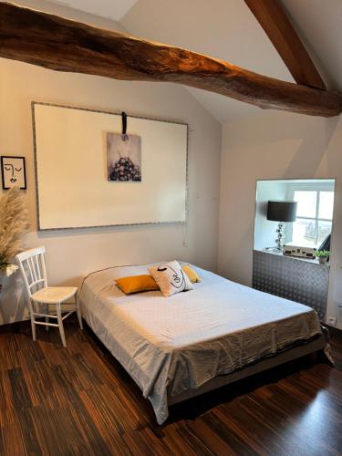 une chambre avec un lit et une chaise dedans dans l'établissement Loft du château, à Brains-sur-Gée