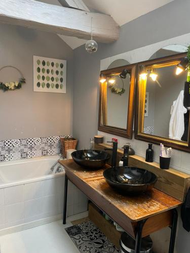 une salle de bain avec deux lavabos et une baignoire dans l'établissement Loft du château, à Brains-sur-Gée