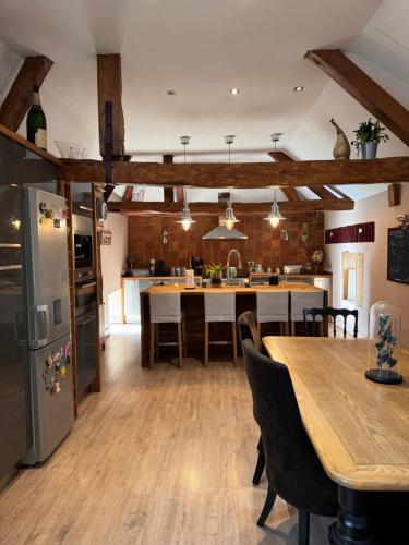 une cuisine avec une table et un réfrigérateur dans l'établissement Loft du château, à Brains-sur-Gée