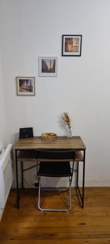een houten tafel met een stoel in een kamer bij Studio Paris 11 Bien situé et fonctionnel in Parijs
