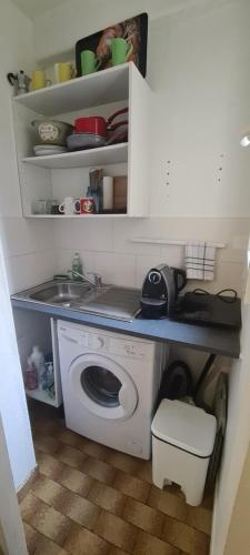 een kleine keuken met een wasmachine en een wastafel bij Studio Paris 11 Bien situé et fonctionnel in Parijs