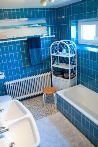 a blue tiled bathroom with a tub and a sink at Buddha Lounge in Dinkelsbühl