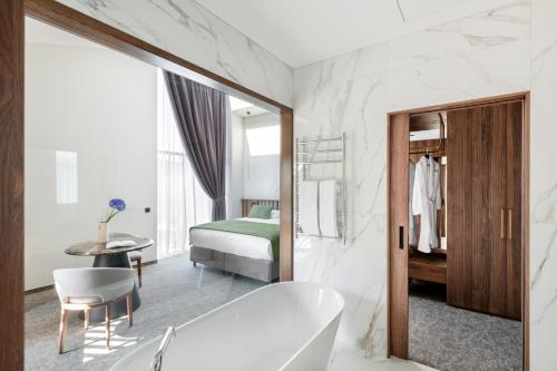 a bathroom with a tub and a bedroom at Harmony Birštonas in Birštonas