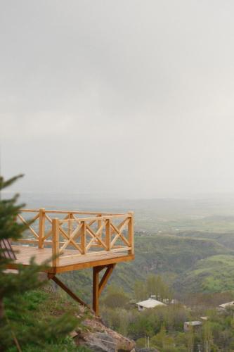 a wooden bench on the side of a mountain at IN CLOUDS RESORT Byurakan in Antarut
