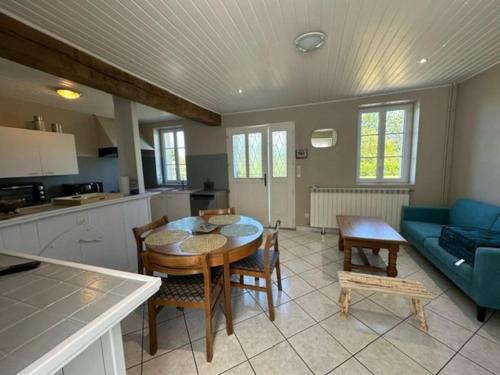 une cuisine et un salon avec une table et des chaises dans l'établissement Maison campagne Normande, à Blacqueville