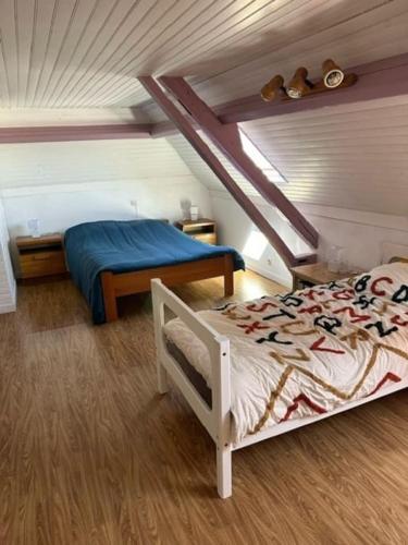 une chambre avec un lit dans un grenier dans l'établissement Maison campagne Normande, à Blacqueville