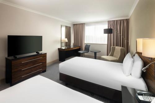 a hotel room with two beds and a flat screen tv at Crowne Plaza Glasgow by IHG in Glasgow