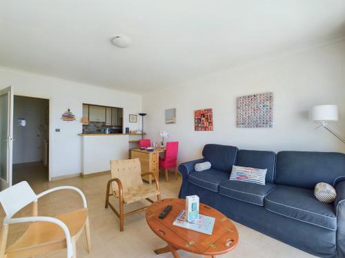 un salon avec un canapé bleu et une table dans l'établissement Escapade en duo - Vue et emplacement privilegiés, à Les Sables-dʼOlonne