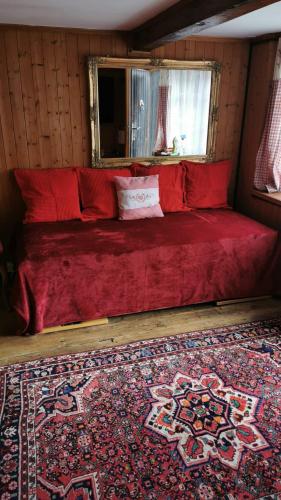 a large red bed in a room with a rug at Studio By Apartments Capricorn No Parking in Gsteigwiler
