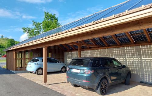 two cars parked in a garage with a roof at KRISTOMI Weinbergvillen in Oberburgstall
