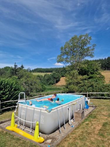 - une grande piscine dans un champ avec des personnes dans l'établissement La Tourette with private pool and nearby swimming lake, à Saint-Genès-la-Tourette
