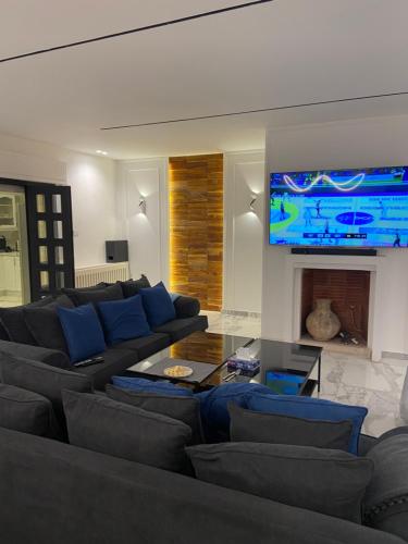 a living room with a couch and a tv at Immaculate apartment in Umm Uthainah