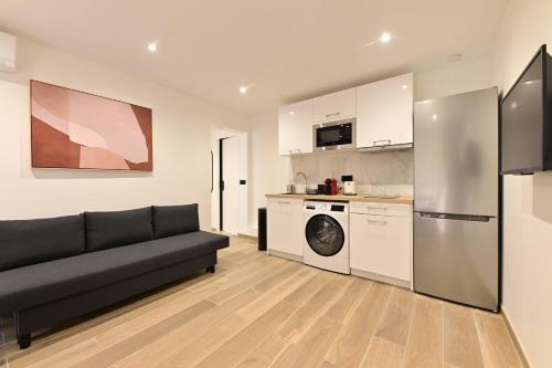 un salon avec un canapé et une cuisine dans l'établissement Appartement Climatisé Porte Versailles, à Paris