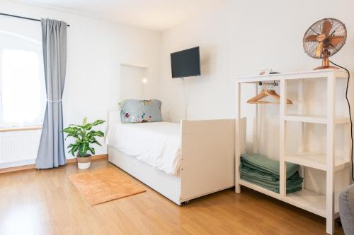 a bedroom with a white bed and a book shelf at Hôtel Restaurant La Croix Verte Vich in Vich