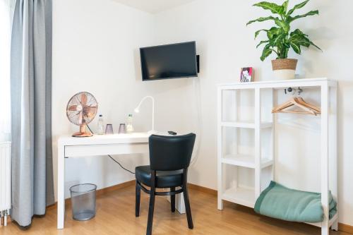 a white desk with a chair next to a white shelf at Hôtel Restaurant La Croix Verte Vich in Vich