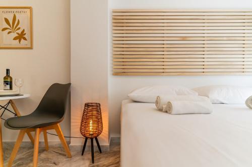 a bedroom with a bed and a chair and a table at AcroLofts M62 in Athens