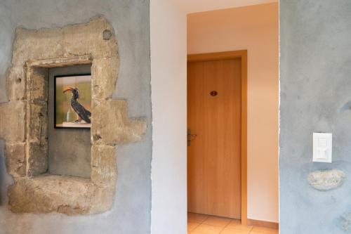 a wall with a picture of a bird in a mirror at Hôtel Restaurant La Croix Verte Vich in Vich