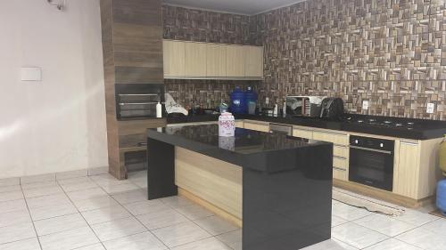 a kitchen with a black counter top in a room at Comfort and Style White Queen II in Cuiabá