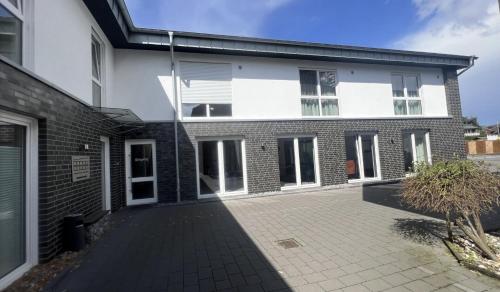 a white and black house with a courtyard at Living-Apartments-Harsewinkel in Harsewinkel
