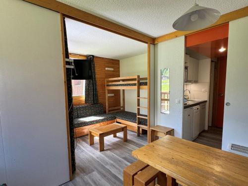 Cette petite maison dispose d'une table à manger et de lits superposés. dans l'établissement Studio confortable avec accès direct aux pistes, animaux admis et WIFI gratuit - FR-1-181-2169, à La Plagne Tarentaise