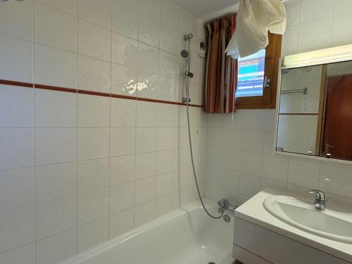 une salle de bain avec une baignoire et un lavabo dans l'établissement Appartement 2 pièces, skis aux pieds, terrasse, animaux admis, Belle Plagne - FR-1-181-2299, à La Plagne Tarentaise