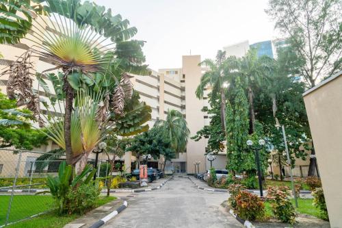 an empty street in front of a building with palm trees at Sigma Base Apartments in Lagos