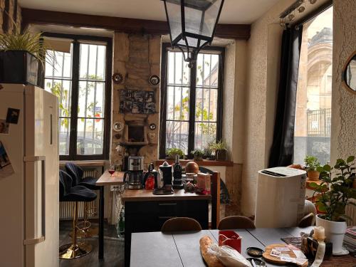 d'une cuisine avec une table et un réfrigérateur. dans l'établissement Charme&caractère, à Dijon